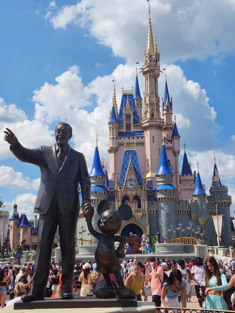 A statue of Walt and Mickey is seen in front of Cinderella Castle at Magic Kingdom.