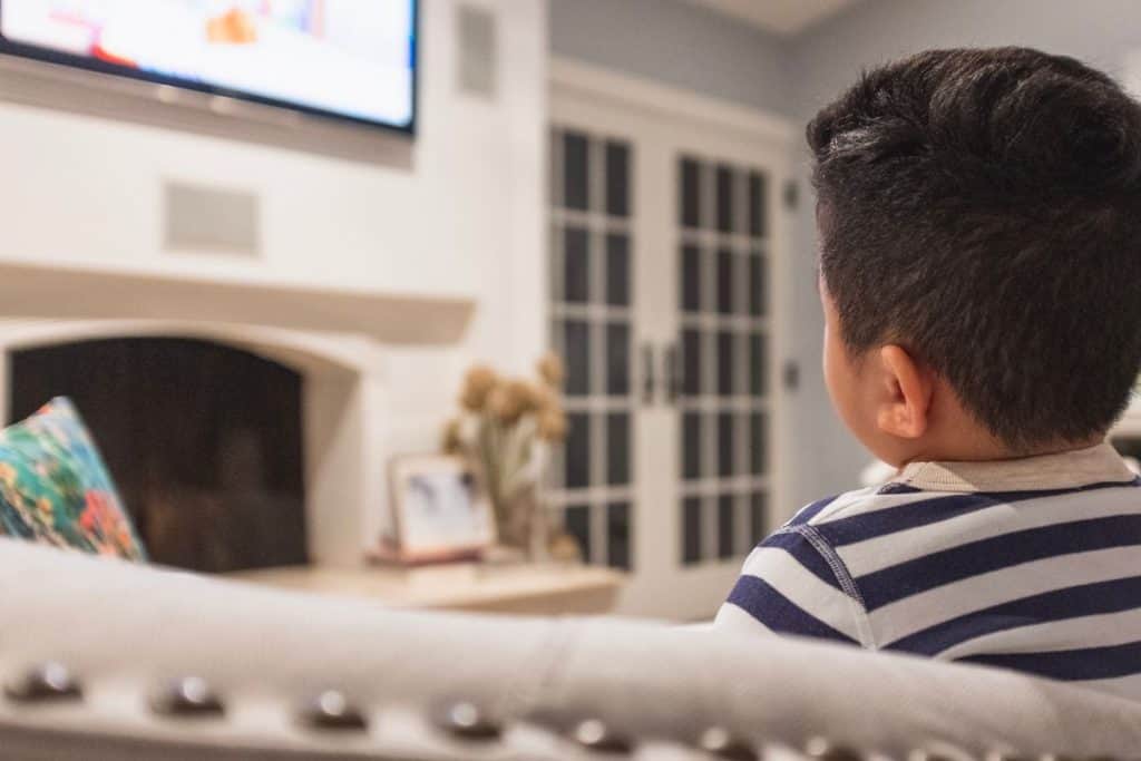 A young child watching TV.