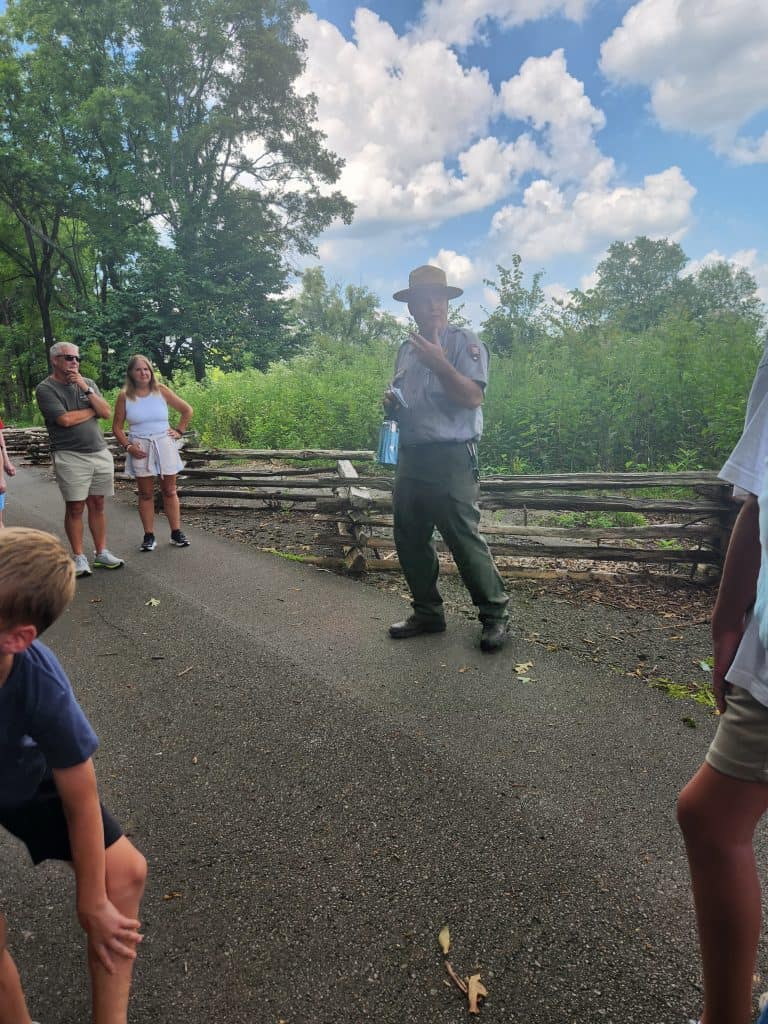 A park ranger guides a group through a reenactment.