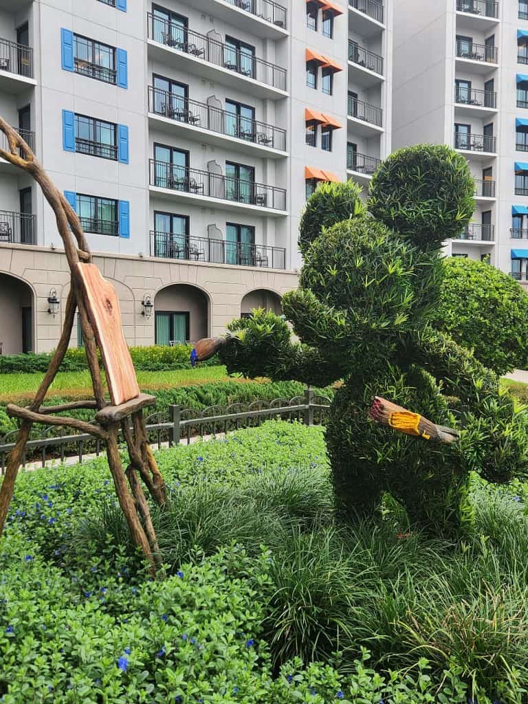 A topiary of Mickey painting in the courtyard.